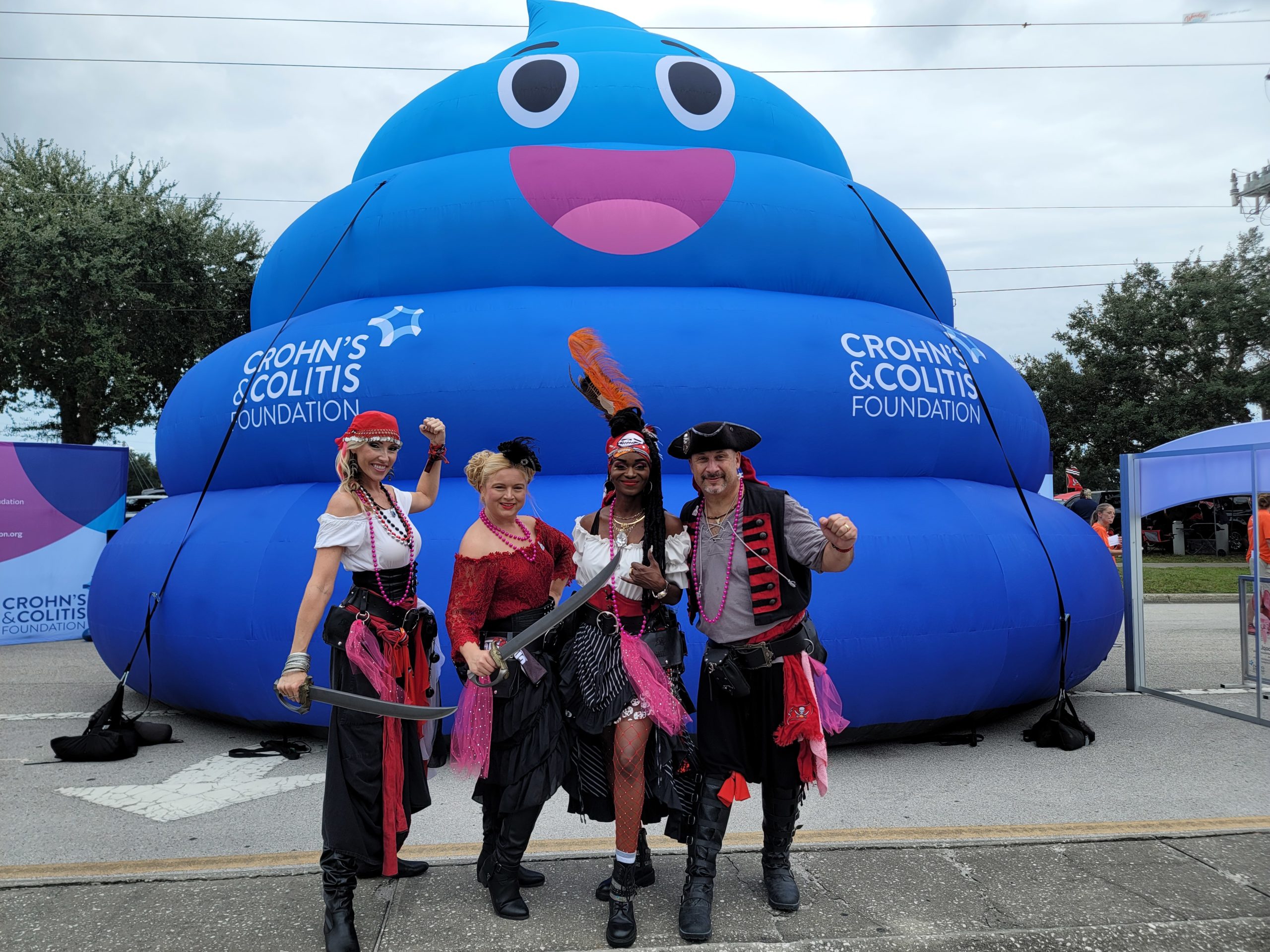 People in pirates costumes posing with a blue inflatable tent